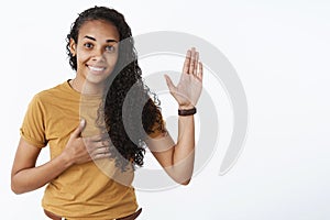 I swear geez. Portrait of cute and friendly happy young nice african-american girl with curly hair raising palm and photo