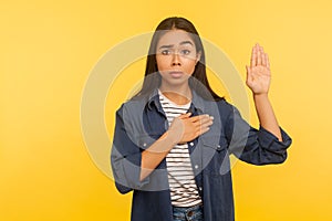 I swear! Portrait of honest girl in denim shirt taking sacred oath, making solemn vow in ceremonial tradition