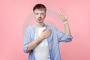 I swear! Portrait of honest serious brown-haired man keeping hand on chest and making promise oath. isolated on pink background