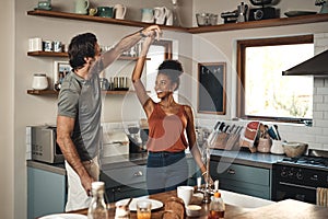 I thank the heavens for sending me you. an affectionate young couple dancing together in their kitchen at home.