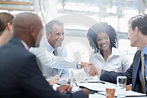 I think we have an agreement. Two businessmen reaching an agreement while sitting around a table with other