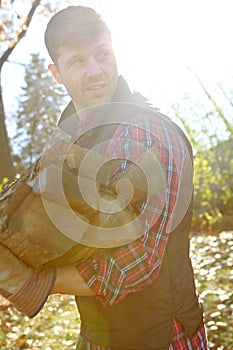 I think theres enough here...A handsome lumberjack holding a pile of wood he has collected. Young man in the forests