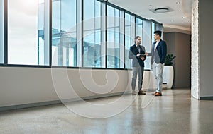 I think you have a great tool to help you grow. two young businessmen using a digital tablet together in a modern office