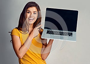 I too couldnt believe it when I saw it. Studio portrait of an attractive young woman pointing to a laptop with a blank