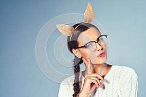 I tried to be normal once, never again. Studio shot of a young woman wearing costume rabbit ears against a plain