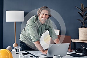 I turn visions into a reality. Portrait of a handsome young architect working on a laptop in his office.