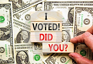 I voted. Did you symbol. Concept words I voted. Did you on beautiful wooden block. Beautiful dollar bills background. Voter hand.