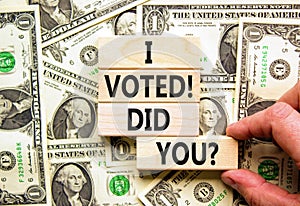 I voted. Did you symbol. Concept words I voted. Did you on beautiful wooden block. Beautiful dollar bills background. Voter hand.