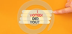 I voted. Did you symbol. Concept words I voted. Did you on wooden stick. Beautiful orange table orange background. Voter hand.