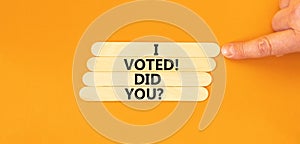 I voted. Did you symbol. Concept words I voted. Did you on wooden stick. Beautiful orange table orange background. Voter hand.