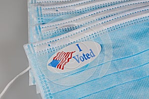 I Voted paper sticker on medical face mask to illustrate in person voting