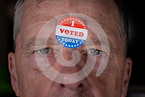 I Voted Today paper sticker on mans forehead with angry stare at camera