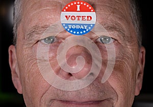 I Voted Today paper sticker on mans forehead with warm smile at camera