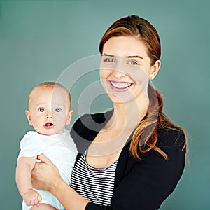 I want to provide the best for my little boy. Studio shot of a successful young businesswoman carrying her adorable baby