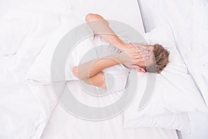 I want to sleep. early morning wakeup. sleep disorders concept. man has sleep problems. man lying white bedroom. time to