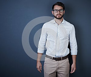 I was born confident. Studio portrait of a handsome young businessman standing against a dark background.