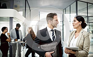 I was hoping to pick your brain...two businesspeople looking at a tablet in the office.