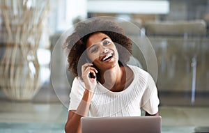 I was just emailing you. Portrait of an attractive young woman talking on the phone while using a laptop.