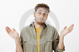 I was uninvolved, no nothing. Portrait of confused and unaware handsome mature guy with beard and curly hair in casual