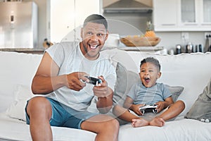 I wasnt even looking. a young man playing video games with his son at home.