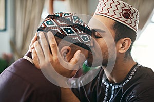 I will always keep you in my heart. a young muslim father affectionately giving his son a forehead kiss.