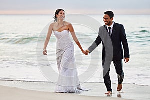 I will love you in word and deed. Shot of a young couple on the beach on their wedding day.
