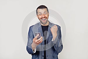 I am a winner Happy business man holding a smartphone and celebrating his victory and success is very excited, encouraging