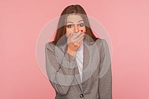 I won`t tell anyone! Portrait of frightened intimidated woman in business suit keeping her mouth closed