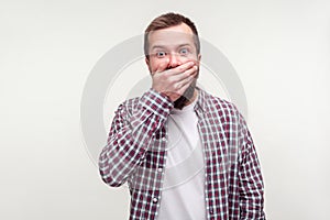 I won`t tell! Portrait of intimidated bearded man covering mouth with hand, scared to testify. white background