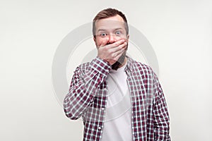 I won`t tell! Portrait of intimidated bearded man covering mouth with hand, scared to testify. white background photo
