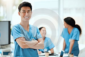 I work with the best team of doctors. a young male doctor standing with his arms crossed at a hospital.