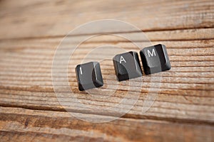 I AM wrote with keyboard keys on wooden background