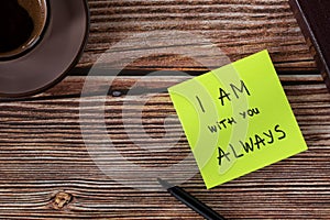 I AM with you always, handwritten biblical verse on note with holy bible book and cup of coffee on wooden background, top view