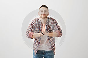 I am at your service, sensei. Indoor shot of positive emotive young guy in glasses bowing while greeting someone in