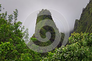 Iao Needle green peak surrounded by misty clouds, Iao Valley State Park, Hawaii