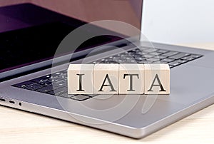 IATA word on wooden block on laptop, business concept