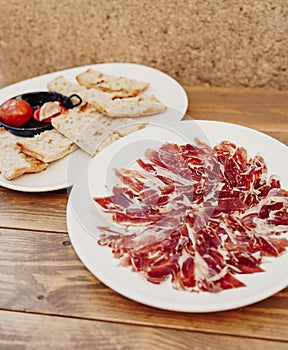 Iberian ham, also known as JamÃ³n IbÃ©rico, is a type of cured ham that is highly prized in Spain photo