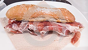 Iberic ham sanwich in a white dish.