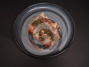 Iberico Pork Collar Steak with Chimichurri served in a dish isolated on dark background top view photo