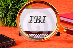 IBI symbol through a magnifying glass on a business card. Business concept photo