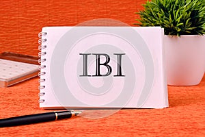 IBI symbol on a white sheet of a notebook. Business concept photo