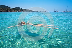 Ibiza bikini girl swimming clear water beach