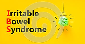 IBS irritable bowel syndrome symbol. Concept words IBS irritable bowel syndrome on a beautiful yellow background. Light bulb.
