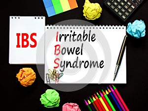 IBS irritable bowel syndrome symbol. Concept words IBS irritable bowel syndrome on white note on a beautiful black background.