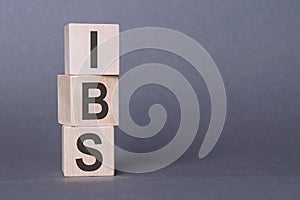 IBS - Irritable Bowel Syndrome, text written on wooden blocks, on gray background