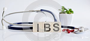 IBS the word is written on wooden cubes and sthetoscope and piils . Medicine photo