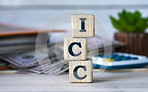 ICC - Abbreviation for wooden cubes on the background of a folder, cactus and banknotes photo