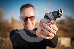 Police agent and bodyguard pointing pistol to protect from attacker photo