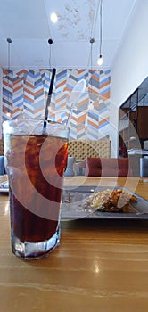 Ice Americano and Bakwan (Indonesian Fritter) on the table from eye view angle
