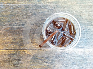 Ice americano coffee in pastic cup top down view put on the old wood table